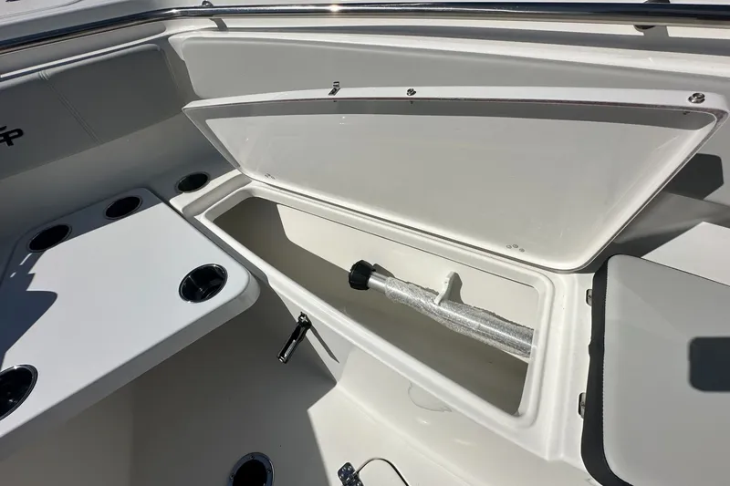 Slide: The Image of 2026 Sea Pro 262 Offshore boat storage compartment with cup holders and stainless steel fittings. - 7
