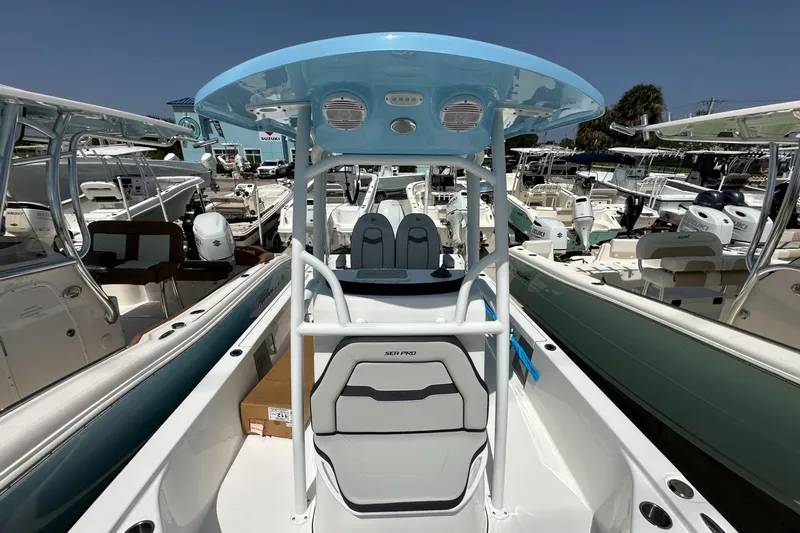 Slide: The Image of 2026 Sea Pro 250 Bay boat with blue T-top, docked among other boats. - 8
