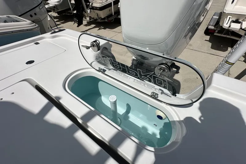 Slide: The Image of 2026 Sea Pro 250 Bay boat with livewell and motor, docked outdoors. - 13