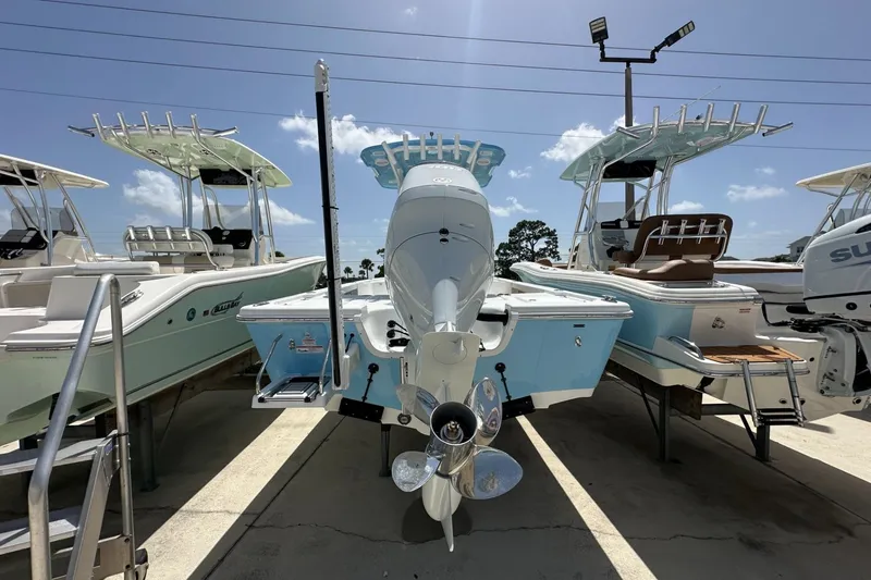 Slide: The Image of 2026 Sea Pro 250 Bay boat displayed outdoors, surrounded by other boats under a clear sky. - 2