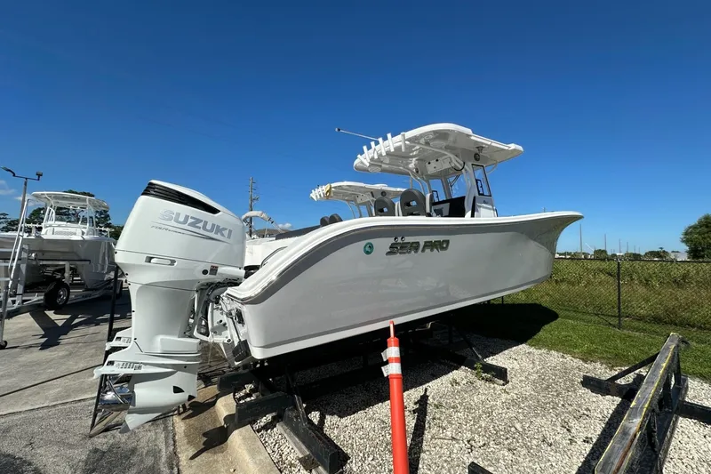Slide: The Image of 2026 Sea Pro 292 DLX boat with Suzuki engine displayed outdoors under clear blue sky. - 2