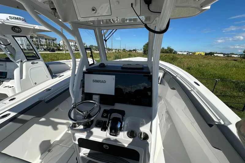 Slide: The Image of 2026 Sea Pro 292 DLX boat cockpit with Simrad navigation system, steering wheel, and controls. - 5