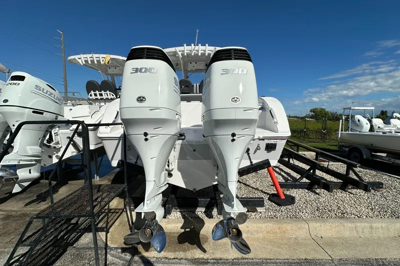 Slide: The Image of 2026 Sea Pro 292 DLX boat with dual 300 horsepower outboard engines, docked outdoors. - 3