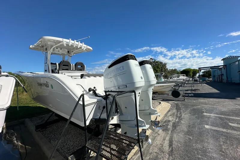 Slide: The Image of 2026 Sea Pro 292 DLX boat with dual Suzuki engines, parked outdoors under a clear blue sky. - 4