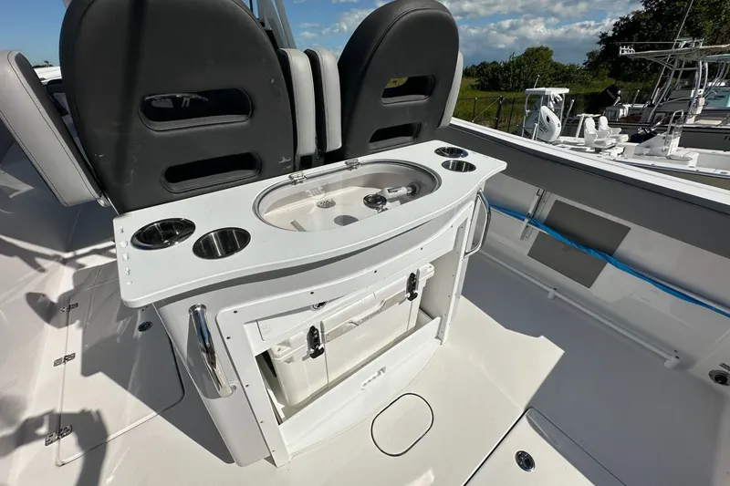 Slide: The Image of 2026 Sea Pro 292 DLX boat interior with seating and built-in cup holders. - 16