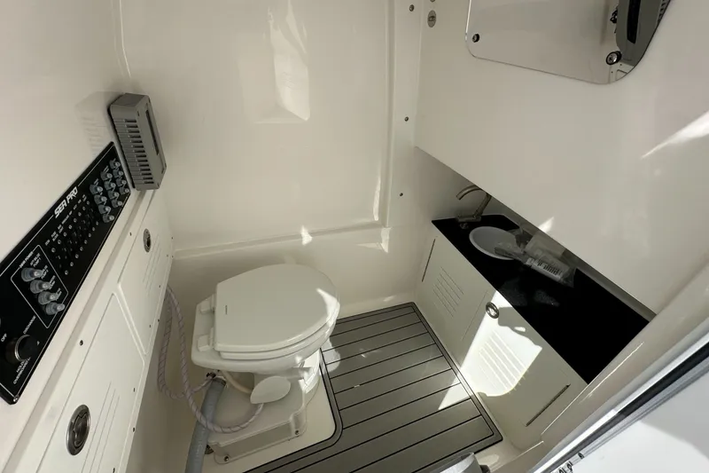 Slide: The Image of 2026 Sea Pro 292 DLX boat interior with toilet, sink, and control panel. - 11