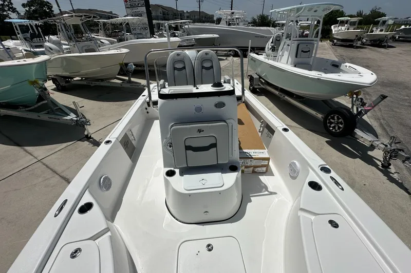 Slide: The Image of 2026 Sea Pro 230 Bay boat interior, showcasing seating and console, in a dealership lot. - 10