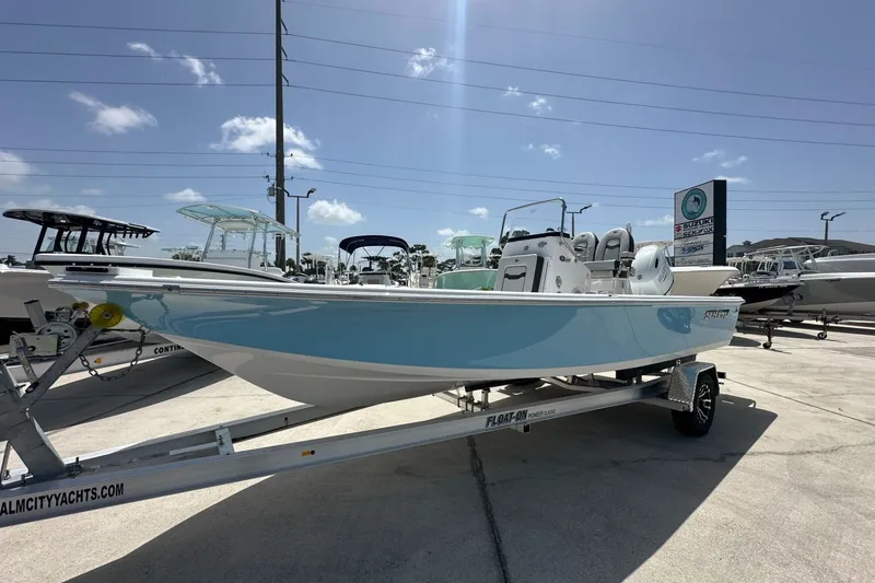 Slide: The Image of 2026 Sea Pro 230 Bay boat on trailer at dealership under clear sky. - 1