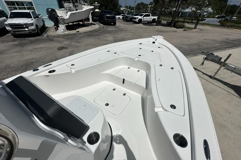 Slide: The Image of 2026 Sea Pro 230 Bay boat displayed in a dealership lot with other vehicles. - 5