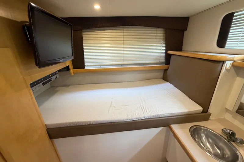 Slide: The Image of 1996 Carver 325 Aft Cabin Motor Yacht interior with bed, TV, and sink. - 32