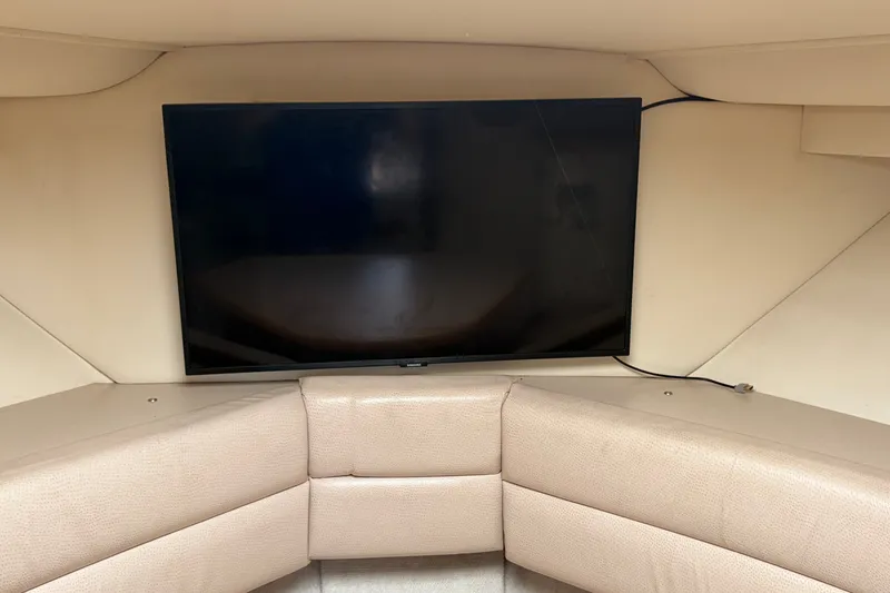 Slide: The Image of Interior of 1996 Carver 325 Aft Cabin Motor Yacht with mounted TV and beige seating. - 23
