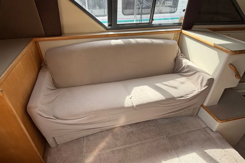 Slide: The Image of Interior of 1996 Carver 325 Aft Cabin Motor Yacht with beige sofa and carpeted floor. - 27