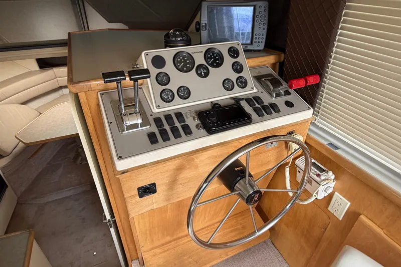 Slide: The Image of 1996 Carver 325 Aft Cabin Motor Yacht helm with steering wheel and control panel. - 24