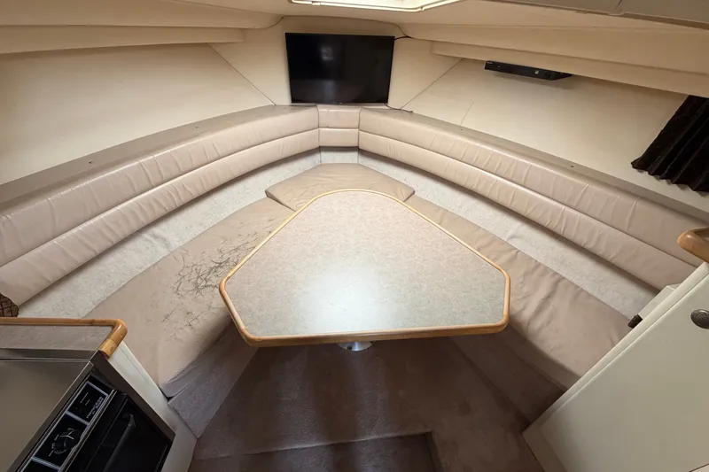Slide: The Image of 1996 Carver 325 Aft Cabin Motor Yacht interior with beige seating and table. - 19