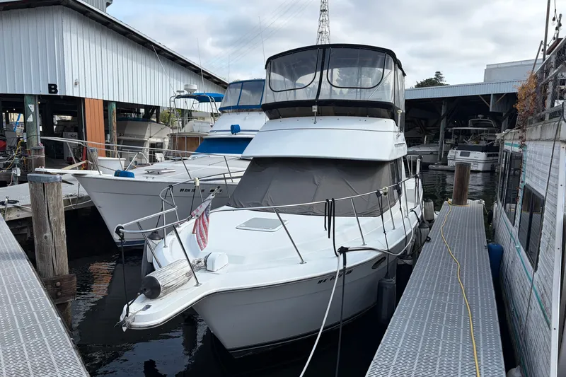 The Image of 1996 Carver 325 Aft Cabin Motor Yacht docked at marina, surrounded by other boats. - 1