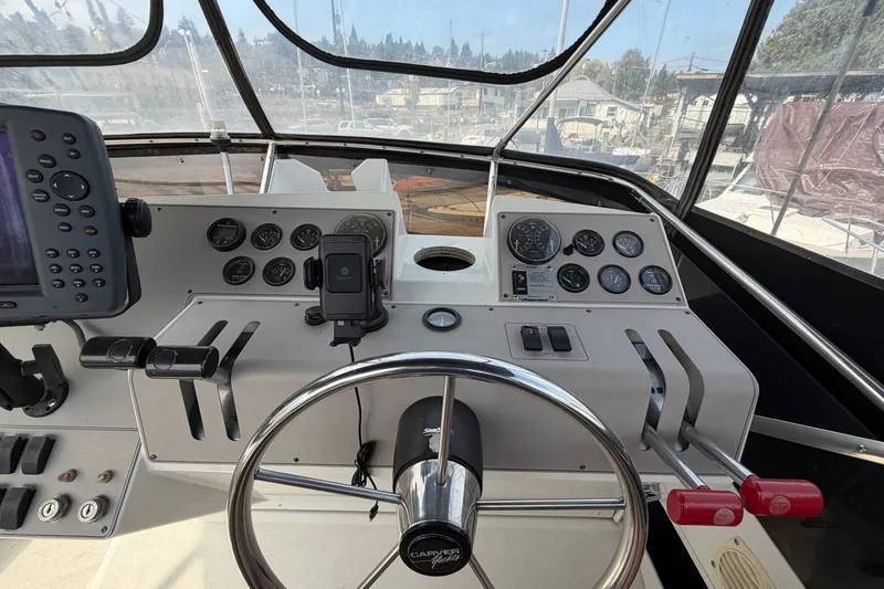 Slide: The Image of 1996 Carver 325 Aft Cabin Motor Yacht helm with steering wheel and control panel. - 14