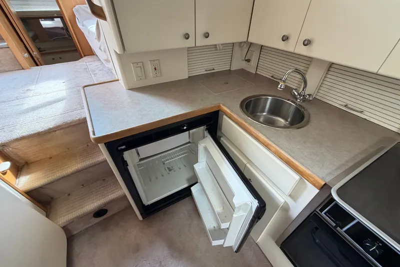 Slide: The Image of 1996 Carver 325 Aft Cabin Motor Yacht kitchen with sink and open fridge. - 16