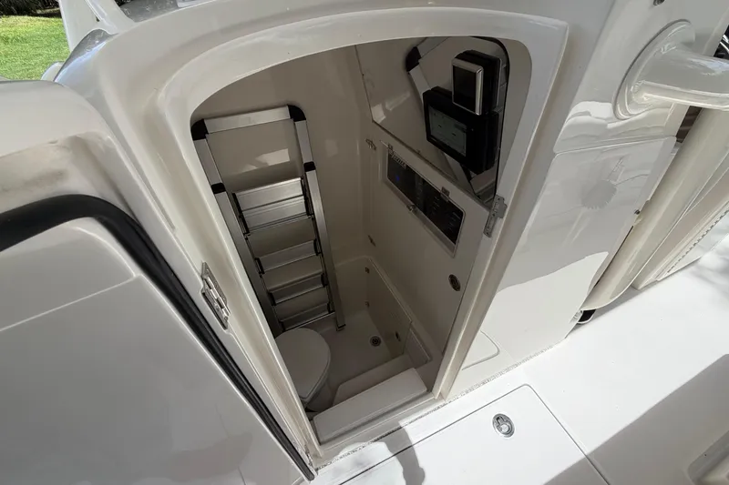 Slide: The Image of Interior view of a 2019 Jupiter 30 boat's compact bathroom with ladder and controls. - 21