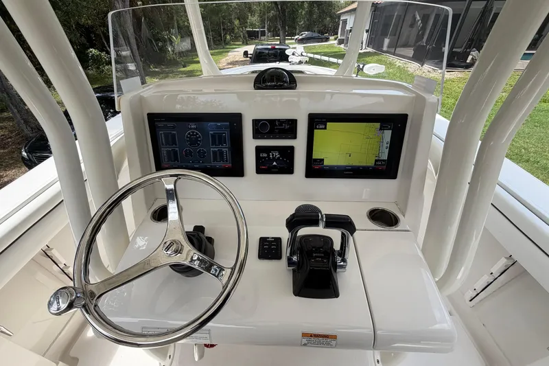 Slide: The Image of 2019 Jupiter 30 boat dashboard with steering wheel, navigation screens, and controls. - 15