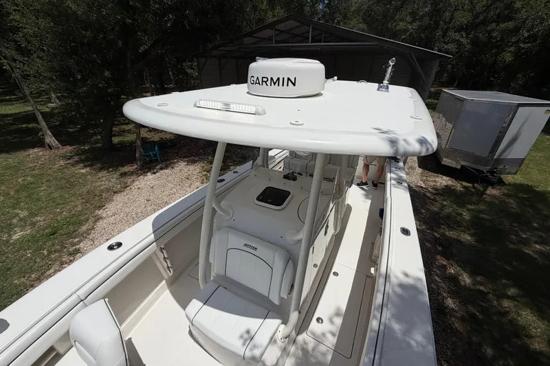 Slide: The Image of 2019 Jupiter 30 boat with Garmin equipment, parked outdoors near trees and a trailer. - 31
