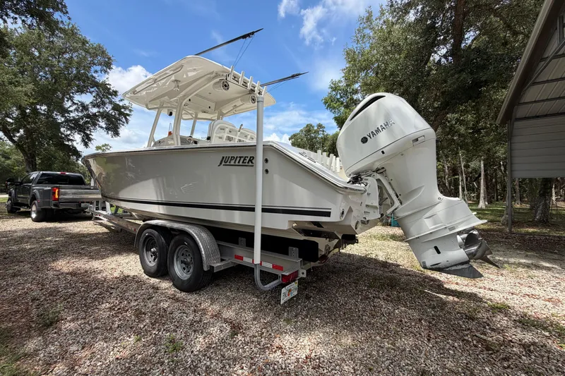 Slide: The Image of 2019 Jupiter 30 boat on trailer with Yamaha engine, parked outdoors under blue sky. - 5