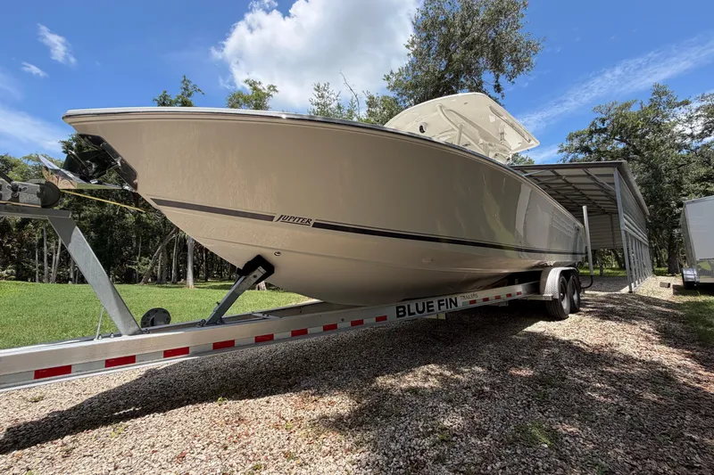 Slide: The Image of 2019 Jupiter 30 boat on Blue Fin trailer under clear sky. - 3