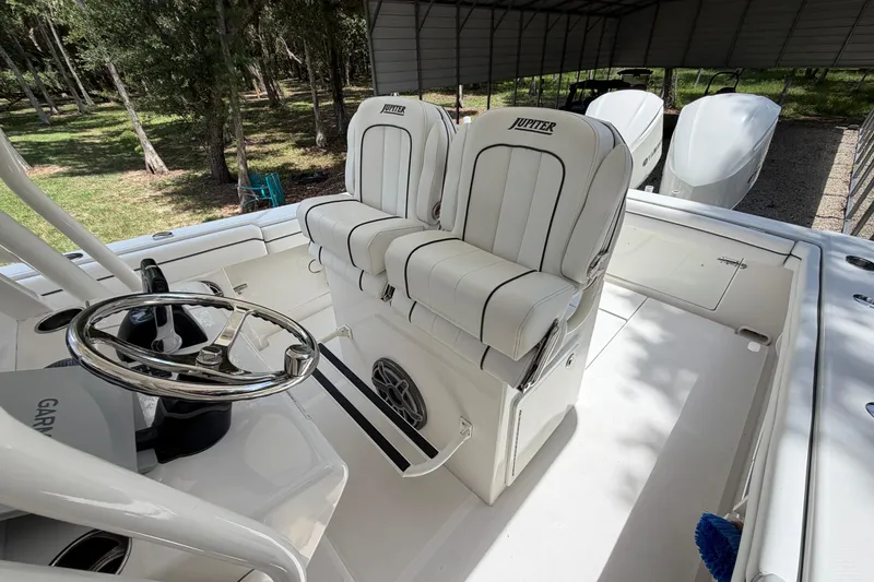 Slide: The Image of 2019 Jupiter 30 boat interior with dual white seats and steering wheel. - 18