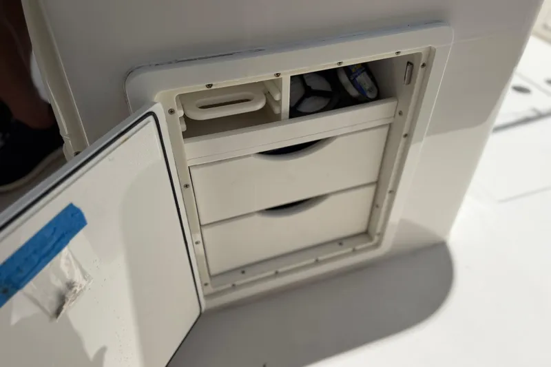 Slide: The Image of Open storage compartment on a 2019 Jupiter 30 boat, featuring drawers and visible contents. - 39