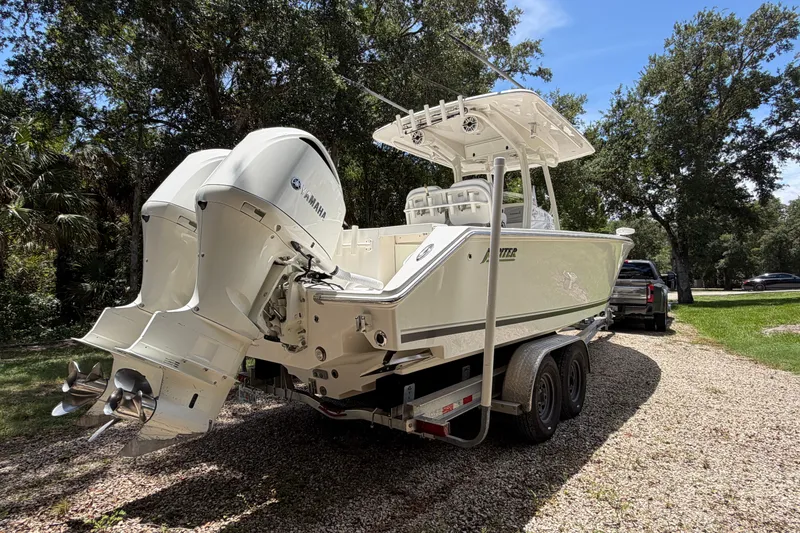Slide: The Image of 2019 Jupiter 30 boat on trailer with dual Yamaha engines, parked outdoors. - 4