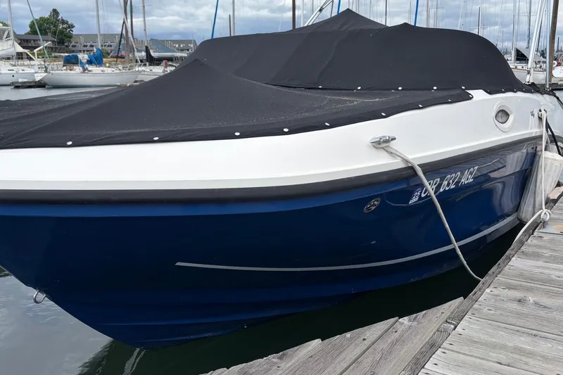 Slide: The Image of 2021 Bayliner VR6 Bowrider I/O boat docked with black cover, blue hull. - 17