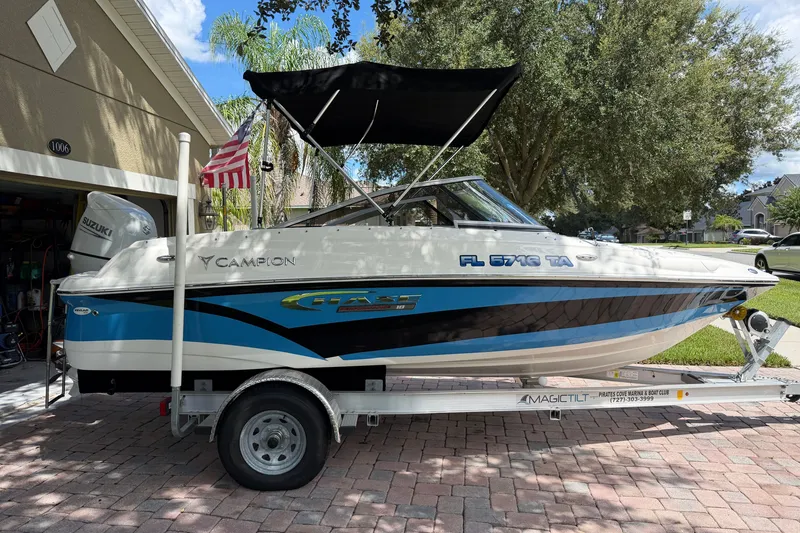 Slide: The Image of 2021 Campion Allante 180 boat on trailer, parked in driveway with American flag. - 4