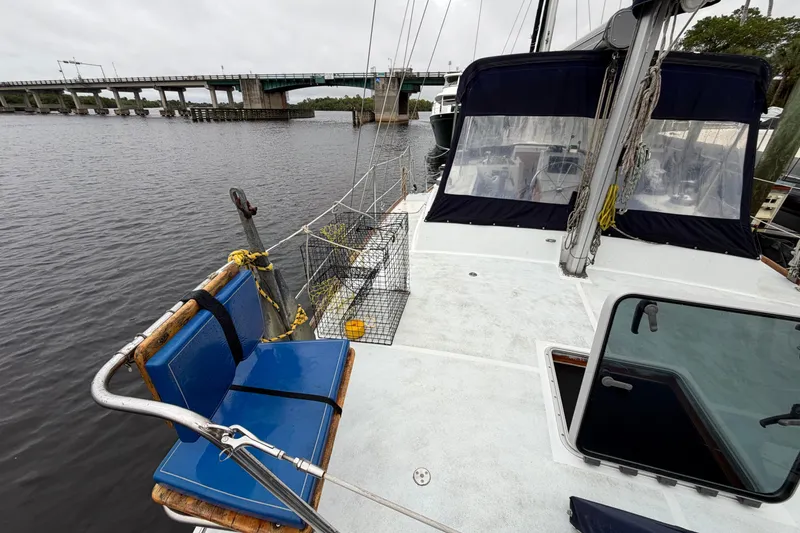 Slide: The Image of Custom Build 50' Ketch, 2011, docked near a bridge, featuring blue seating and pilothouse. - 9