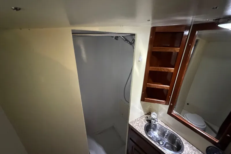 Slide: The Image of 2011 Custom Build 50' Ketch bathroom with shower, sink, and wooden shelving. - 56
