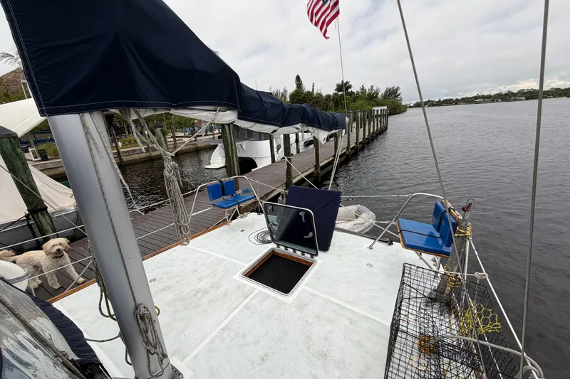 Slide: The Image of Custom Build 50' Ketch docked, featuring pilothouse and deck, with American flag. - 8