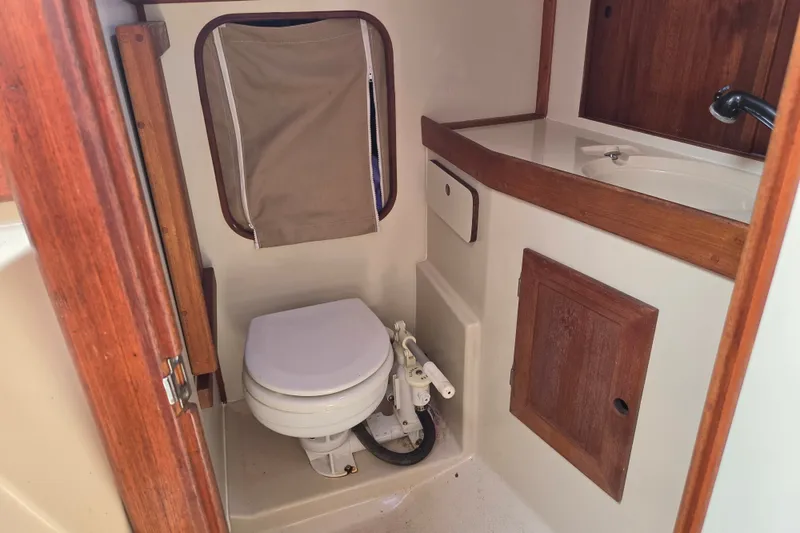 Slide: The Image of 1989 Ericson Olsen 34 yacht bathroom with wooden accents and compact toilet. - 8