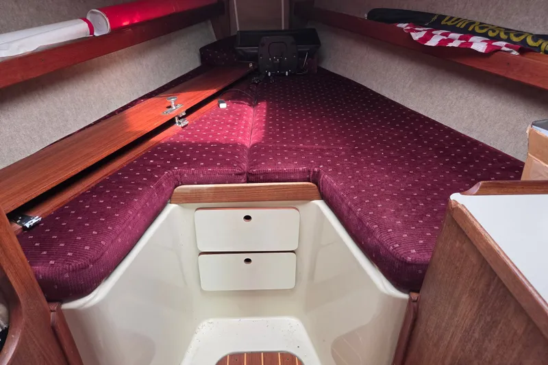 Slide: The Image of Interior cabin of 1989 Ericson Olsen 34 sailboat with maroon cushions and wooden accents. - 4