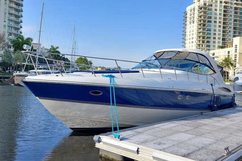 Slide: The Image of 2006 Cruisers Yachts 520 Express docked at marina, blue and white exterior. - 8
