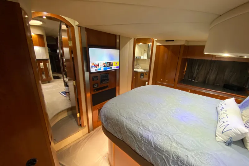 Slide: The Image of Luxurious 2006 Cruisers Yachts 520 Express cabin interior with bed, TV, and wooden finishes. - 69