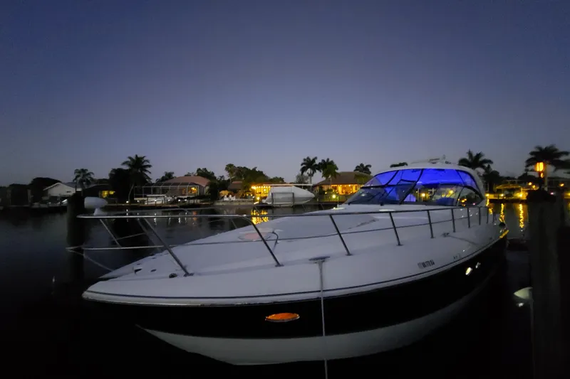 Slide: The Image of 2006 Cruisers Yachts 520 Express docked at twilight with blue cabin lights. - 11
