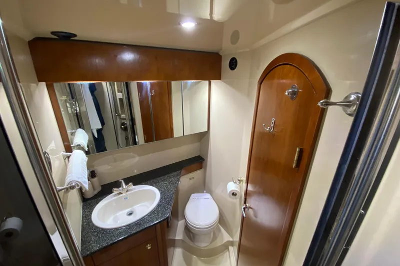 Slide: The Image of Luxurious bathroom in 2006 Cruisers Yachts 520 Express, featuring wood accents and modern fixtures. - 78