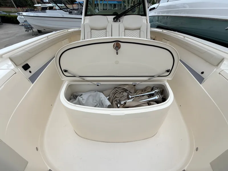 Slide: The Image of The image shows the storage compartment of a 2025 Scout 400 LXF boat with an open lid. - 43