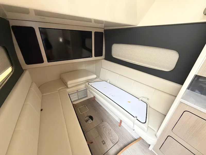 Slide: The Image of Interior of a 2025 Scout 400 LXF featuring sleek white leather sofas and a large screen. - 49