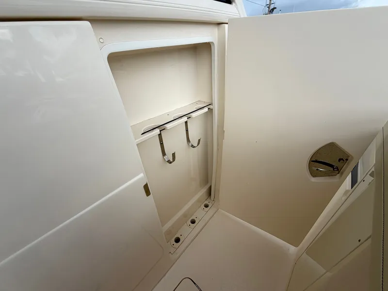 Slide: The Image of A storage compartment with hooks inside a 2025 Scout 400 LXF boat. - 38