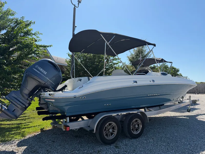 Slide: The Image of A 2024 Stingray 212 SC boat on a trailer with a Yamaha outboard motor. - 1