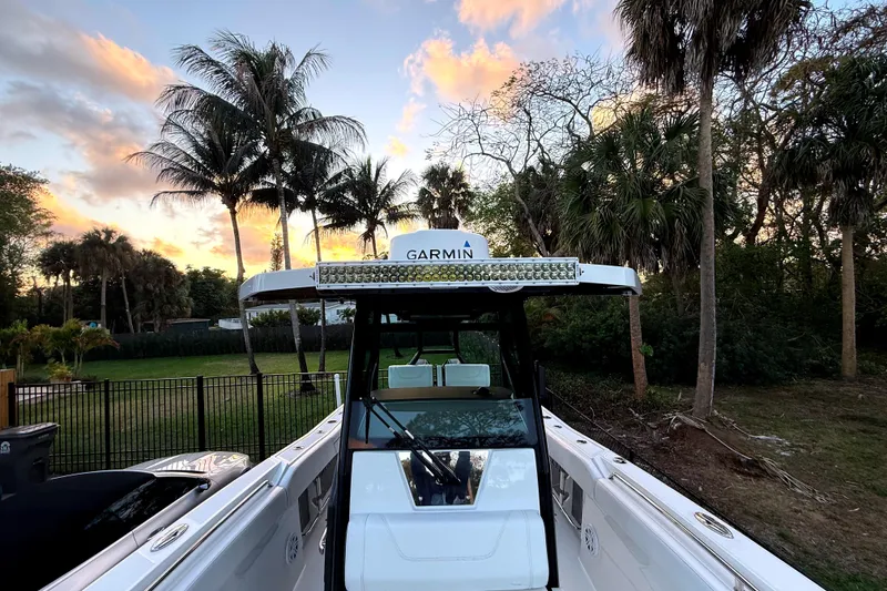 Slide: The Image of 2021 Blackfin 272 CC boat with Garmin equipment, surrounded by palm trees at sunset. - 6