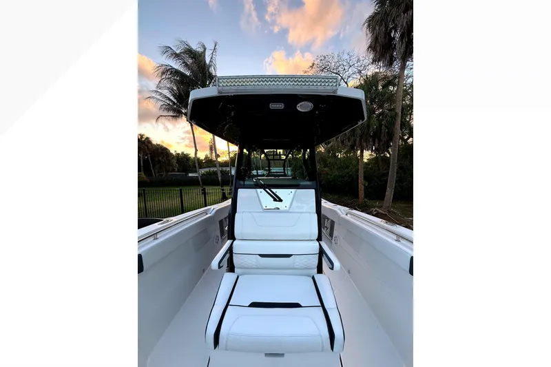 Slide: The Image of 2021 Blackfin 272 CC boat interior with white seating, palm trees in background. - 15