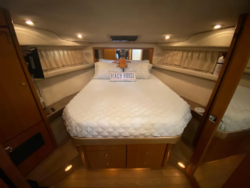 Slide: The Image of Cozy bedroom interior of 2001 Bayliner 3988 yacht with plush bedding and ambient lighting. - 26