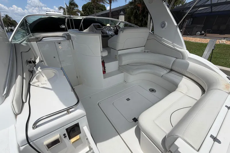 Slide: The Image of 2001 Cruisers Yachts 3672 Express interior with white seating and helm, docked outdoors. - 8