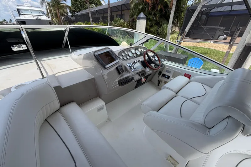Slide: The Image of 2001 Cruisers Yachts 3672 Express helm with modern controls and comfortable seating. - 11