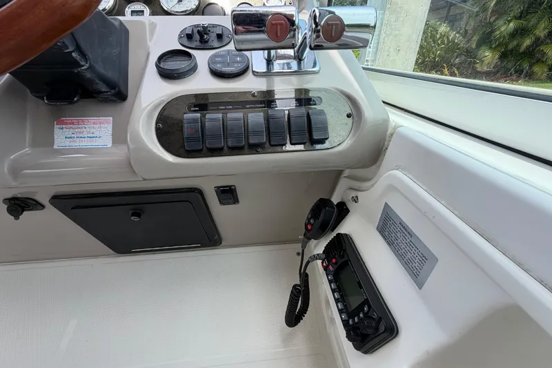 Slide: The Image of 2001 Cruisers Yachts 3672 Express helm with controls, switches, and communication equipment. - 14